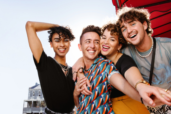 Four friends laughing together outdoors