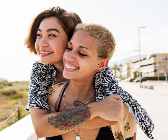 Beautiful multiethnic lesbian couple of lovers dating outdoors - LGBT people bonding and spending time together, concepts about LGBTQ community, diversity, love and lifestyle